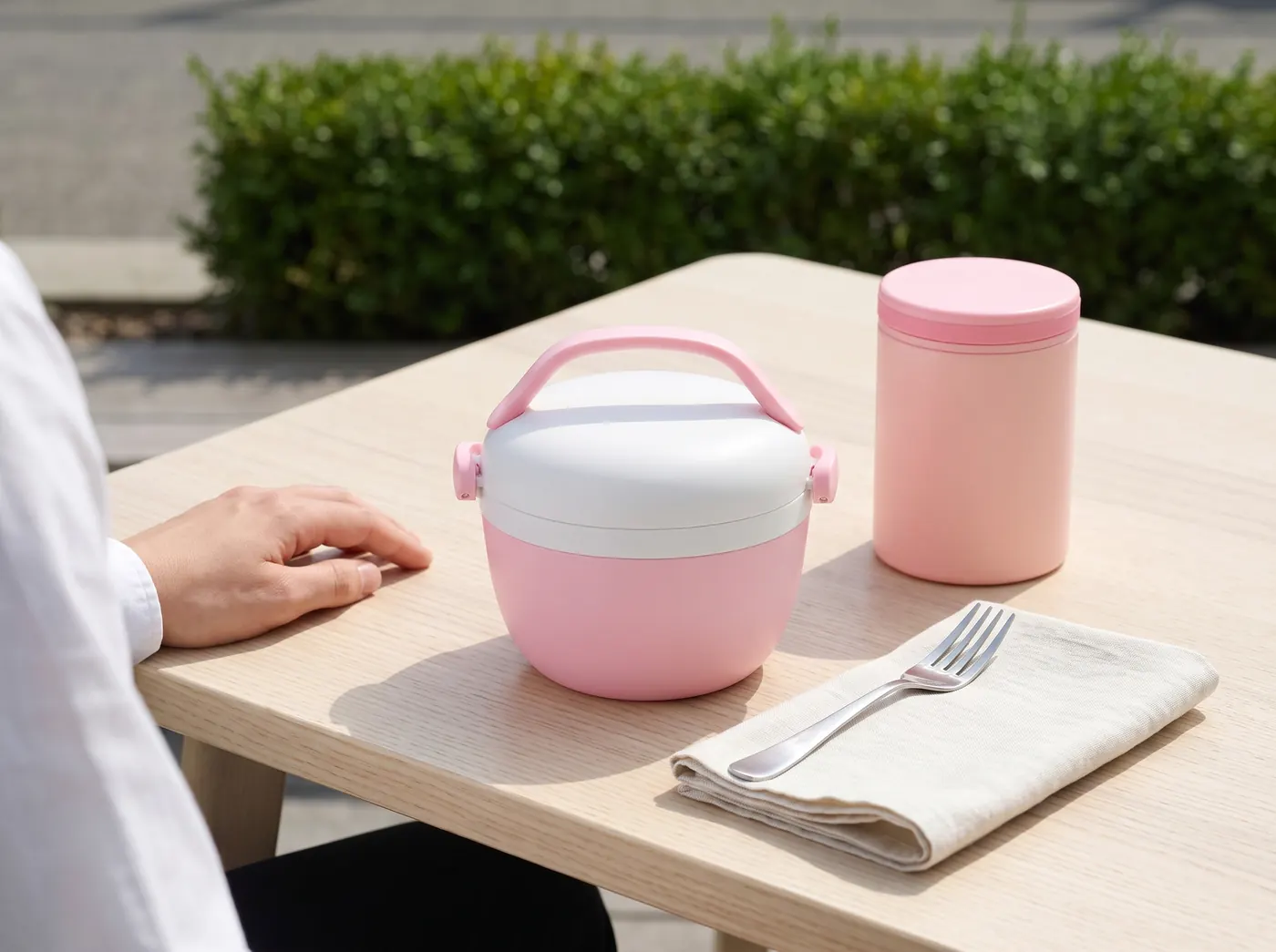 Pink thermal lunch box and food flask Runbott on a terrace table